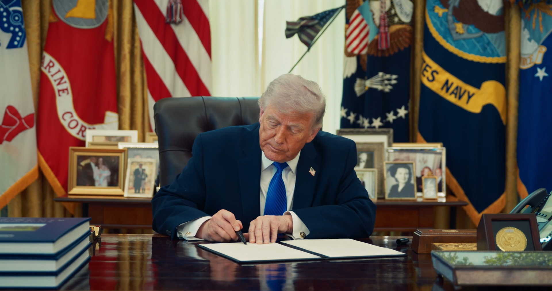 File photo: President Donald Trump signs an executive order in the Oval Office.