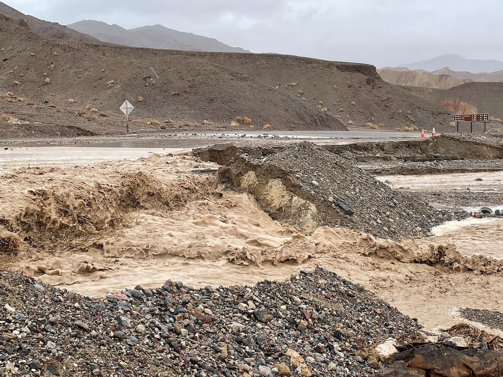 Foto de archivo: Agua de una crecida repentina cruza una carretera del desierto en el Valle de la Muerte, California